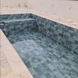 Piscine avec liner aspect mosaïque et margelles en pierre