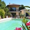 Maison contemporaine conçue pour s'intégrer au paysage, avec piscine, jardin paysager et larges ouvertures sur l'extérieur.