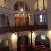 On aperçoit l'orgue derrière les arcs d'architecture romane
