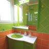 Meuble salle de bains couleur vert et orange. Plan résine blanc