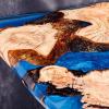 Zoom sur une table de salon en résine bleue et bois de couleur clair.
