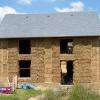 Maison piliers en bauge et remplissage botte de paille sous tension