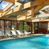 Piscine couverte et chauffée en été et en hiver sous une veranda avec une vue sur les montagnes et un accès au jardin l'été avec transats et bains de soleil. la piscine dispose d'un jacuzzi, de jets d'hydrothérapie et d'une nage a contre courant