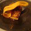 La viande d’agneau était divinement tendre et rosée, et la polenta, d’une légèrement impressionnante.
Le plat était disposé dans une grande assiette creuse noire, décorée d’épices
