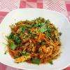 Wok de poulet au curry avec nouilles, légumes et coriandre