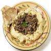 Houmous est une préparation composée notamment de purée de pois chiches et de tahiné accompagnée de viande hachée.