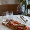 Planche de charcuteries artisanales accompagnée d’un verre de vin rouge naturel, servie sur table en marbre chez Louise by Sharies.