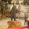 Le décorateur Marcel Robert peignant au sol une maquette.