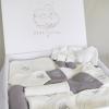 Le coffret Premium de Bébé Coton est notre offre la plus complète et raffinée. Composé de 29 pièces soigneusement sélectionnées, il réunit tout le nécessaire textile pour les premières semaines de vie de bébé. Pensé pour répondre aux recommandations de nombreuses listes de maternité, ce coffret est idéal pour préparer l’arrivée de bébé dans les meilleures conditions ou offrir un cadeau de naissance d’exception.

Décliné dans des tons élégants d’écru et de gris, il propose une garde-robe harmonieuse, un linge doux et des accessoires essentiels, tous conçus pour allier confort, praticité et style.

Contenu du coffret :

7 bodies brodés avec les jours de la semaine
2 bonnets (1 gris + 1 écru)
2 bavoirs bandana (1 gris + 1 écru)
2 couvertures 75×100 cm (1 gris + 1 écru)
2 gilets (1 gris + 1 écru)
2 pyjamas 1 pièce (1 gris + 1 écru)
2 pyjamas 2 pièces (1 gris + 1 écru)
2 paires de chaussons (1 gris + 1 écru)
2 sorties de bain à capuche (1 gris + 1 écru)
4 langes en gaze de coton 50×70 cm (2 gris + 2 écru clair)
1 doudou lapin écru clair
1 gigoteuse zippée, ajustable, manches amovibles
Caractéristiques :

Matière : 100 % coton bio, doux, respirant et respectueux de la peau sensible de bébé
Taille unique : 0-3 mois (standards européens)
Entretien : Lavage à 30°C recommandé, séchage à l’air libre
Couleurs : écru et gris, mixtes et apaisantes
Présenté dans un coffret élégant, prêt à offrir
Ce coffret est idéal pour offrir une expérience haut de gamme aux jeunes parents, en combinant élégance, confort et utilité dès les premiers instants de vie.
