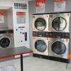 A gauche, 1 machine à laver d'une capacité de 12 kg, 1 de 18 kg et 4 séchoirs.