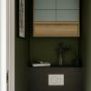 Rénovation de toilettes aux murs vert profond, avec carrelage anthracite, WC suspendu et meuble de rangement sur mesure associant bois naturel et façades vert sauge, un design de Laurence ARNAUD